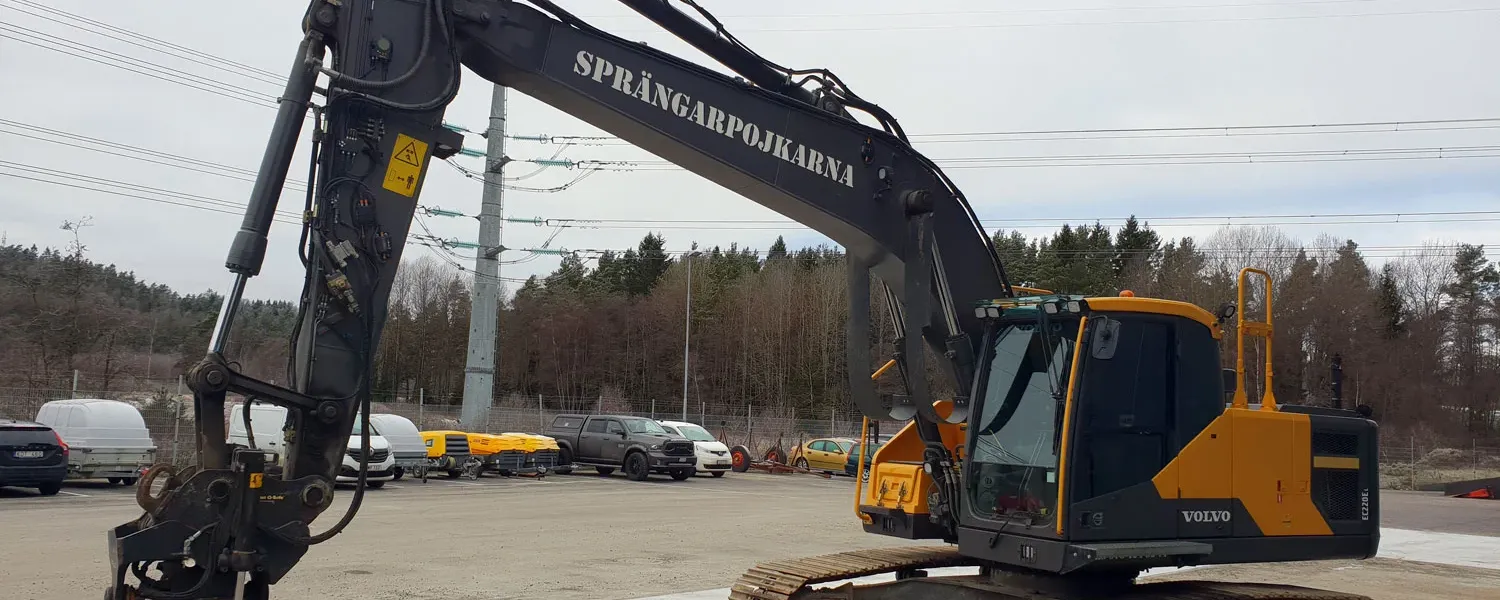 Grävmaskin med Sprängarpojkarnas namn på bommen