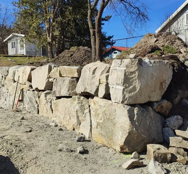 Stödmur av sprängsten vid en villatomt