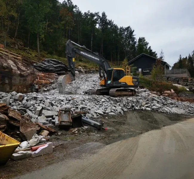 Grävmaskin på en villatomt med sprängsten