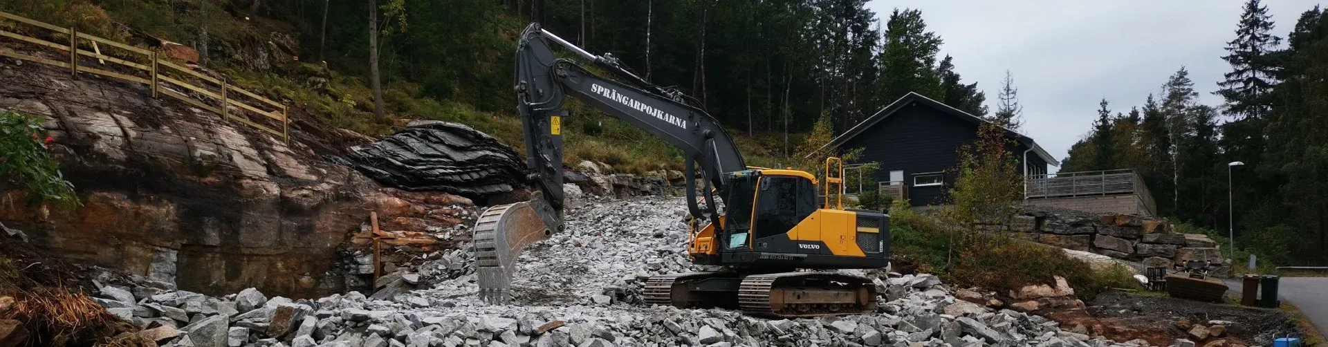 Grävmaskin bland sprängsten vid ett markarbete